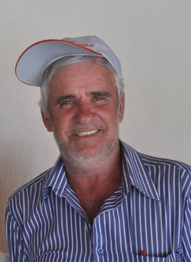 Retrato de Joaquim Cipola, sorrindo, de boné e camisa listrada