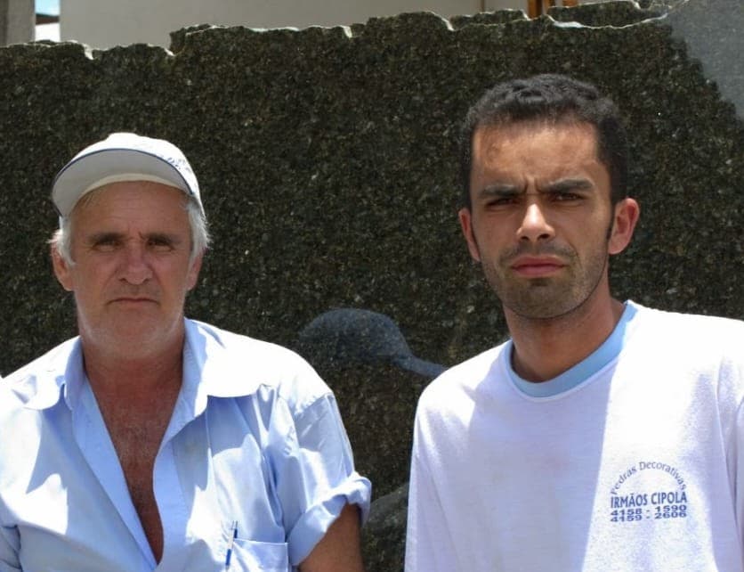 Joaquim e Rafael (Kaka) Cipola diante de uma chapa de granito, Rafael com a camiseta da Pedras Decorativas Irmãos Cipola